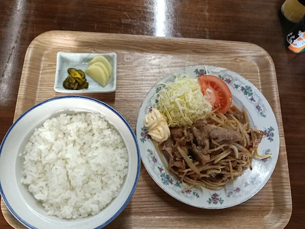 大きなお茶碗に盛られた白米とボリューム満点の豚生姜焼き定食が並ぶテーブル風景