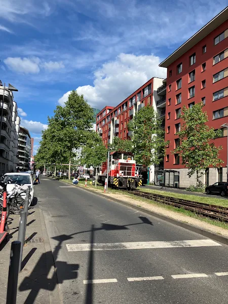赤いディーゼル機関車と線路の街並み。ヨーロッパの都市の中でも「鉄道と共生する生活圏」を感じさせる一枚。