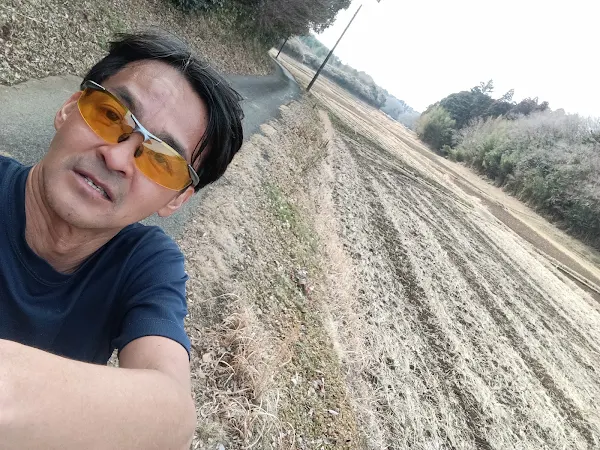 疲労が色濃く残る表情ながら成田の田園地帯を力強く走り続けるサングラスをかけたランナーの自撮り
