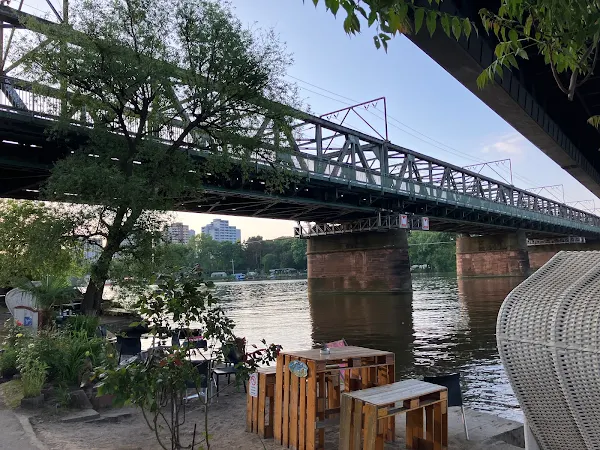  川沿いのビーチエリアから見上げる鉄橋。ローカルな雰囲気漂うカフェが並び、走った後に一息つきたくなる場所。