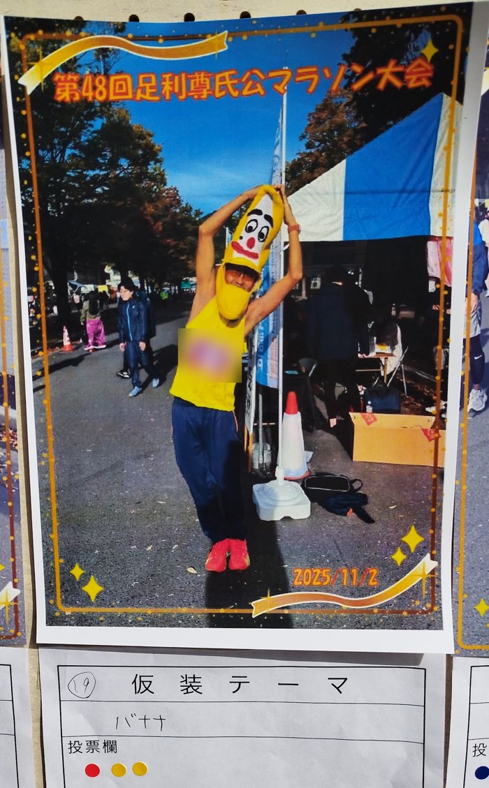第48回足利尊氏公マラソン大会の会場に貼り出された仮装ランナーの写真。バナナの被り物の筆者と、仮装テーマ「バナナ」の投票用紙