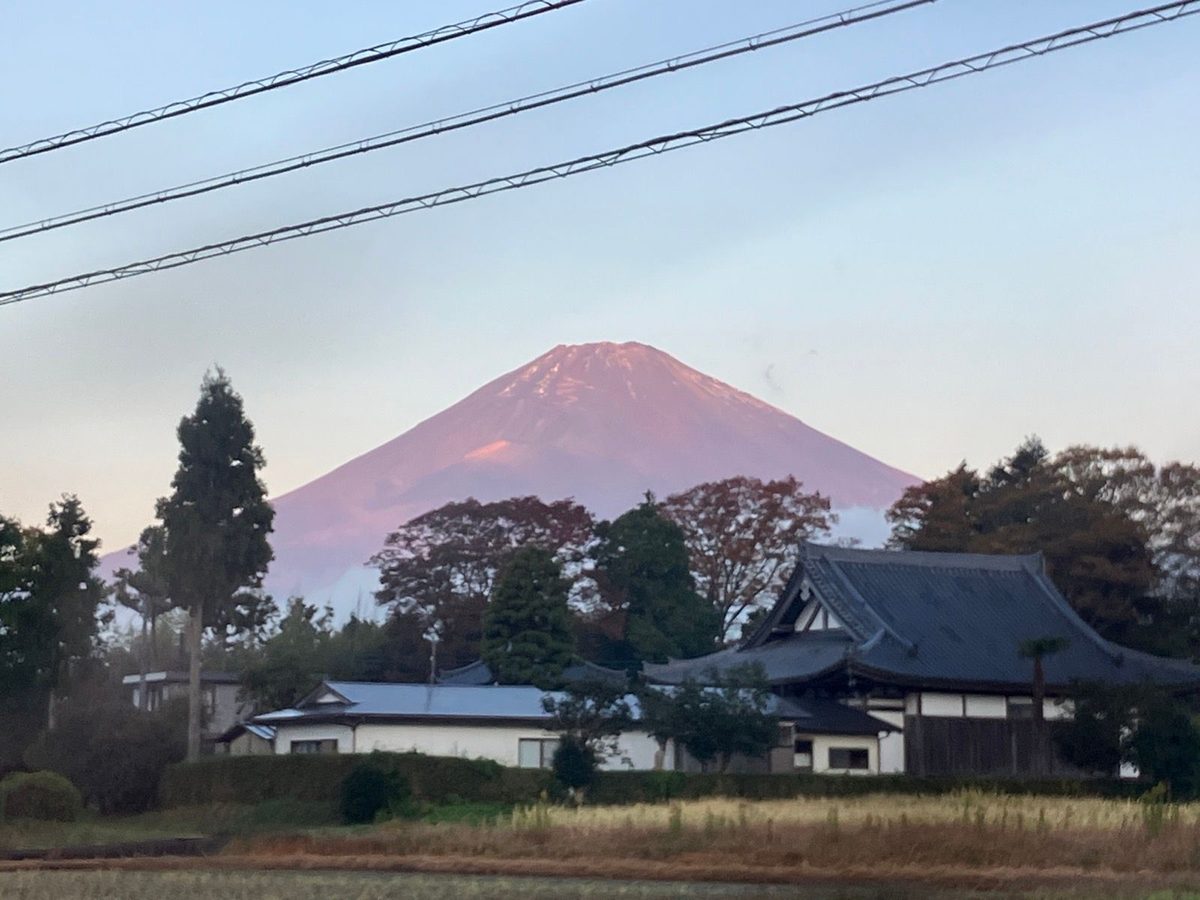 朝日に赤く染まる富士山と御殿場の町