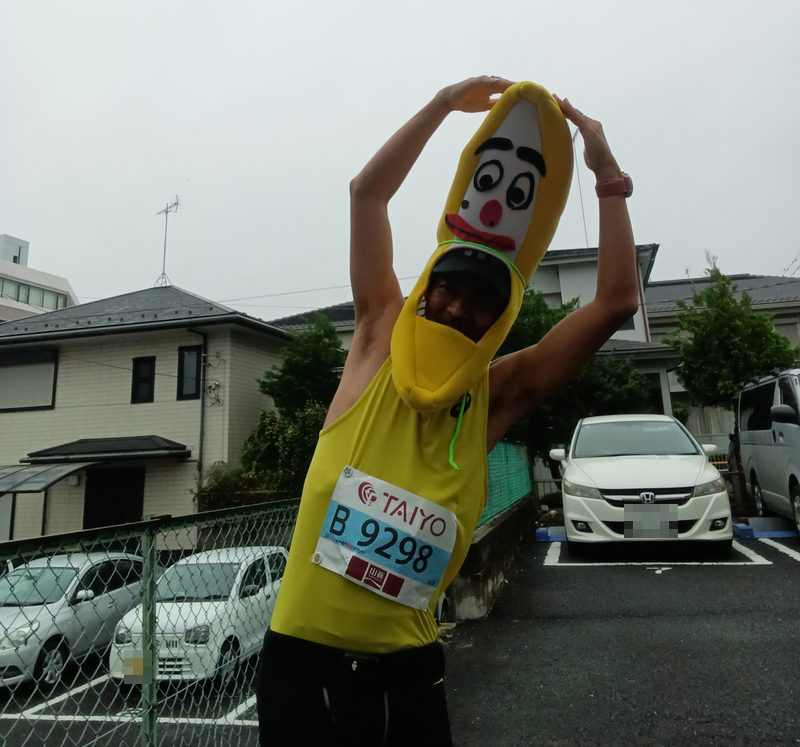 スタート前、バナナの被り物をかぶってゼッケンを付けた筆者が、両手を頭の上で合わせて体を横に倒している