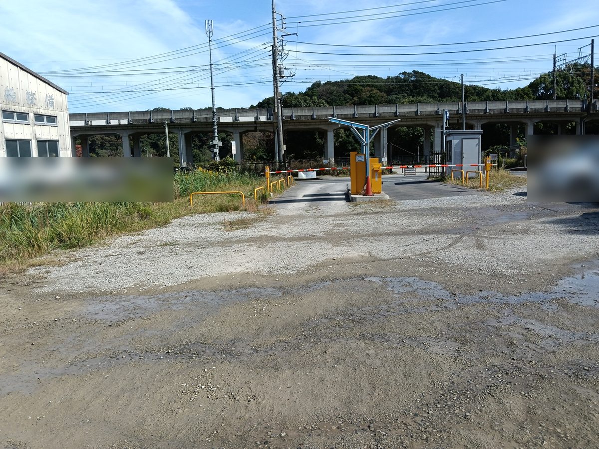 砂利の駐車場と、黄色い精算機と遮断機のある出入口