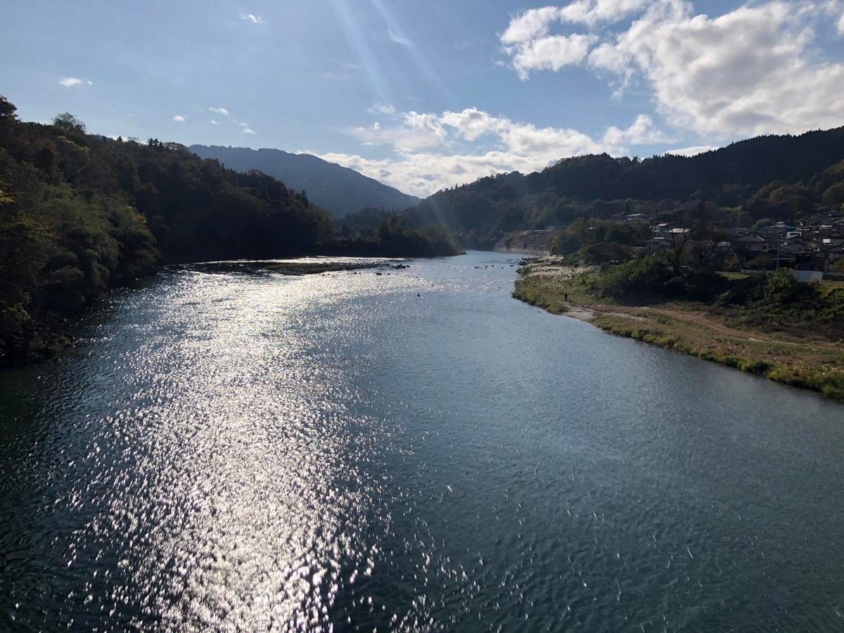 秋の犀川と山並み